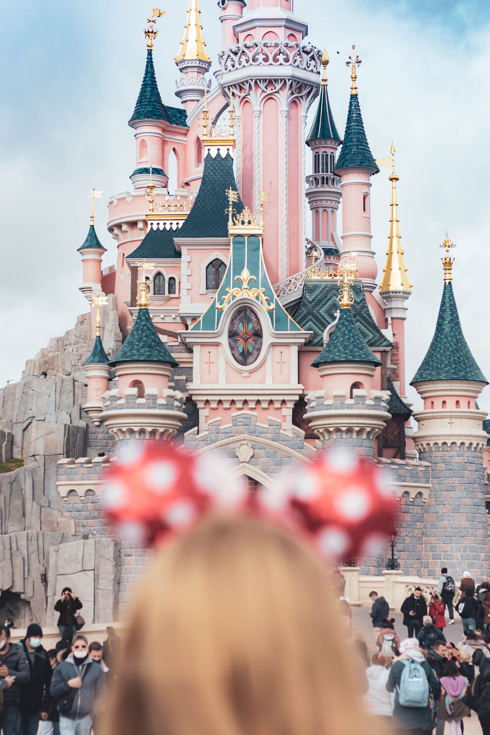 A whimsical castle with crowds at Disneyland Paris, capturing magical family moments.