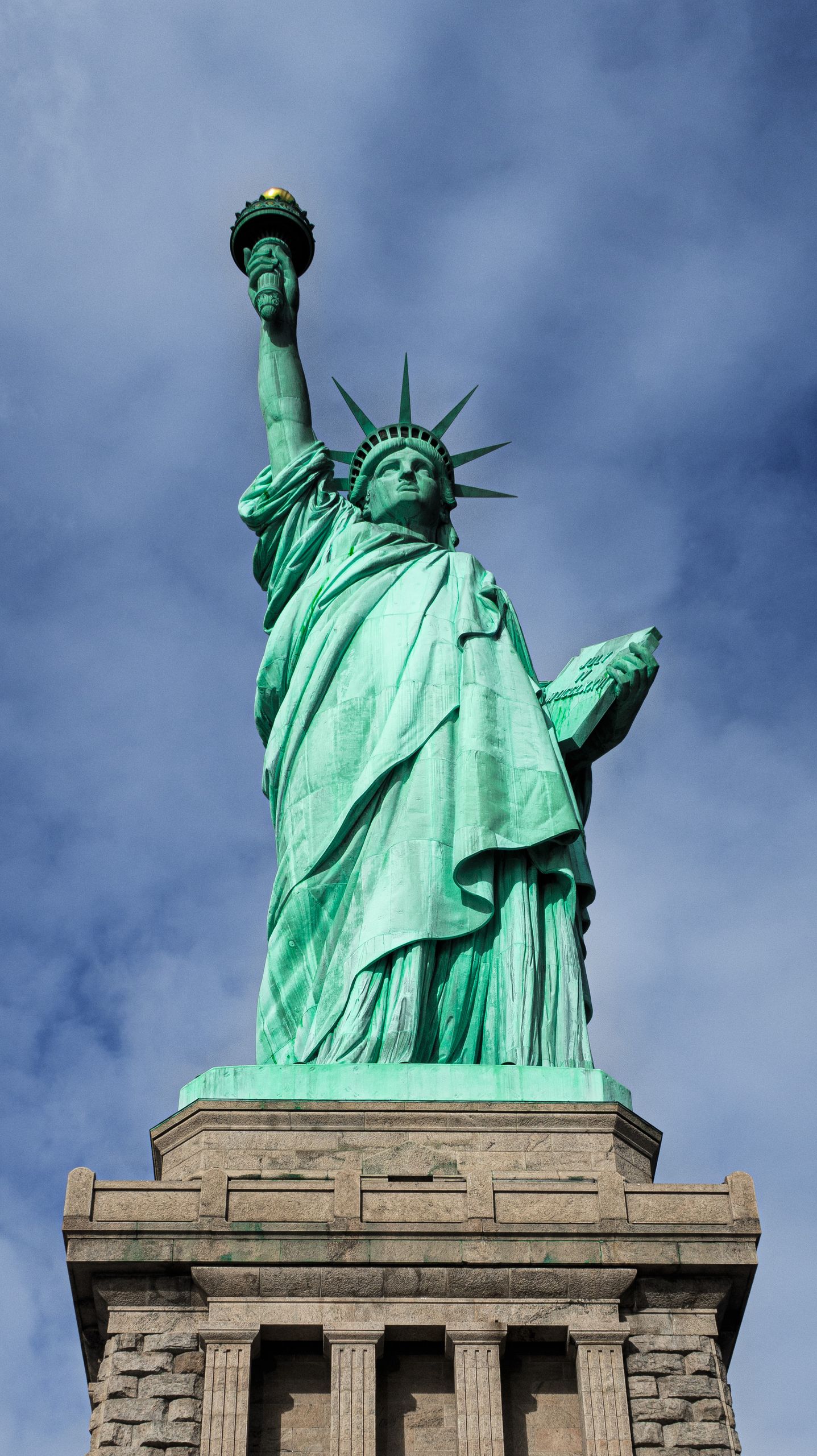 Explore the iconic Statue of Liberty in New York with this stunning vertical shot highlighting its grandeur.